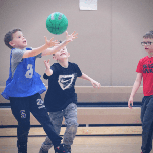Young basketball players trying to intercept a pass.