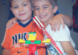 Two buddies get ready to test their waking giant LEGO project.