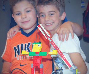 Two buddies get ready to test their waking giant LEGO project.