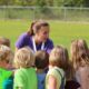 Coach giving pep talk to soccer team.Adult supervision minimizes risky behavior.
