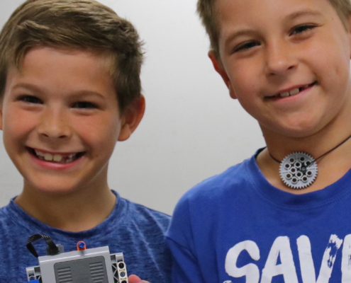 Two boys display their Brick Builders project.