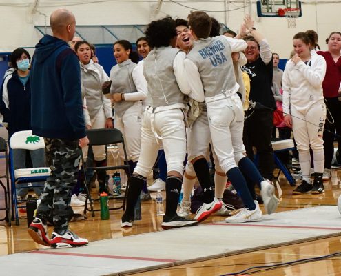2023 Team State Champions, {YEL!} SE MN Fencing Team. All the teammates are huddled and cheering.