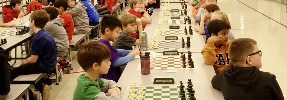 Chess players lined up in long rows of chess boards as they prepare to start their tournament chess games. Chess Club.